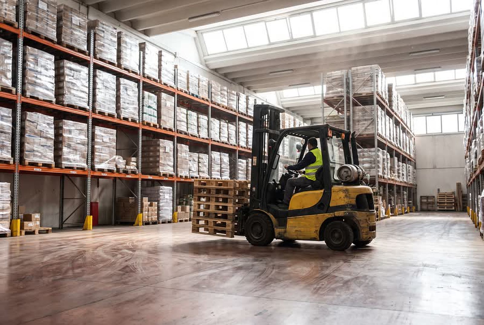 Carrello elevatore frontale che movimenta pallet in un magazzino logistico italiano